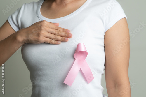 pink badge ribbon on woman chest to support breast cancer cause. breast cancer awareness concept