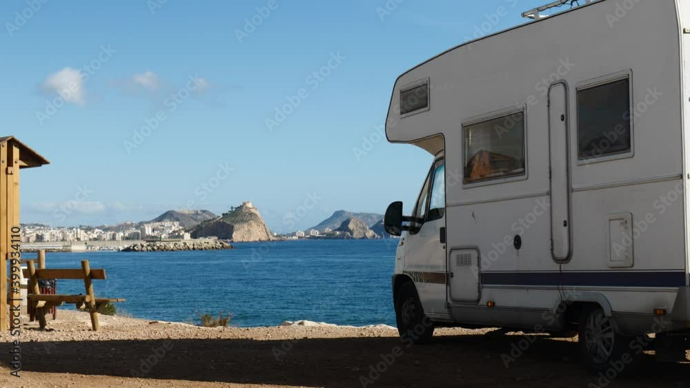 Motor home on spanish coast sea shore. Castle San Juan on mountain in the distance. Aguilas, Murcia region, Spain. Motor home on spanish coast sea shore. Castle San Juan on mountain in the distance. Aguilas, Murcia region, Spain.