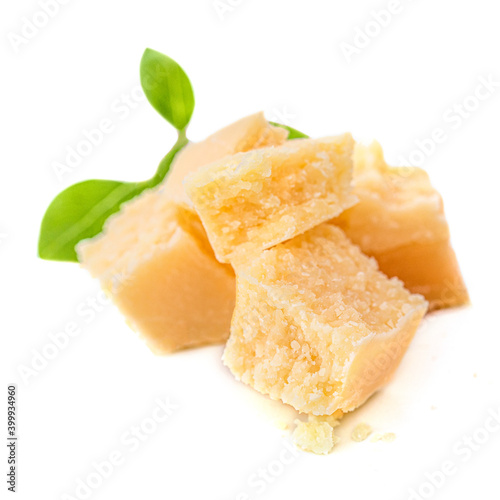 Pieces of Parmesan cheese with basil leaf  isolated on white background. Top view.