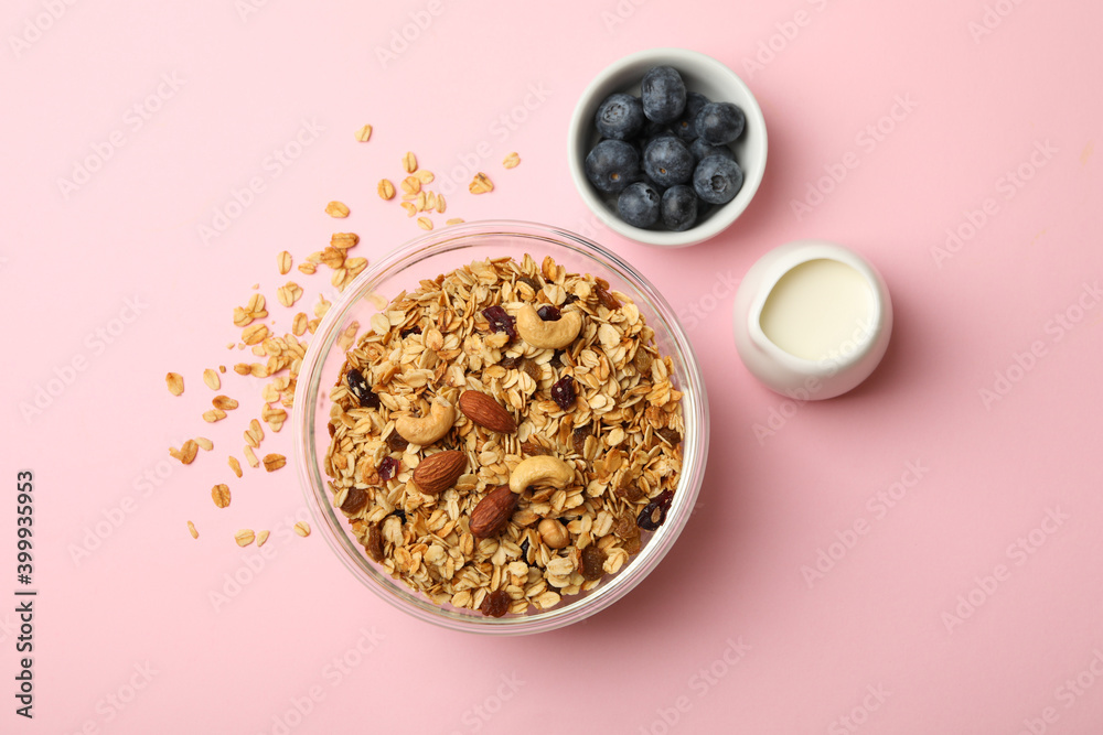Concept of tasty breakfast with granola on pink background