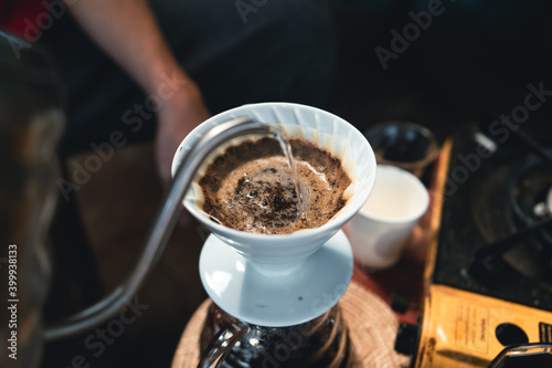 Drip coffee  barista pouring water on coffee ground with filter
