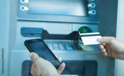 Man holding smartphone and credit card. ATM. Online transaction. Banking