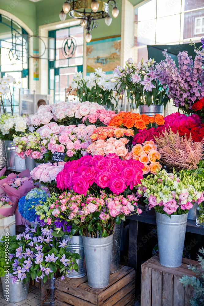 Display of colorful flowers on metal pots inside a shop Display of colorful flowers on metal pots inside a shop
