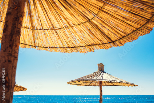 Beach sun umbrellas made of natural material - straw against the sun - a paradise for relaxation
