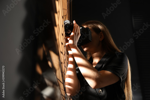 Fotografie Private detective with camera spying near window indoors