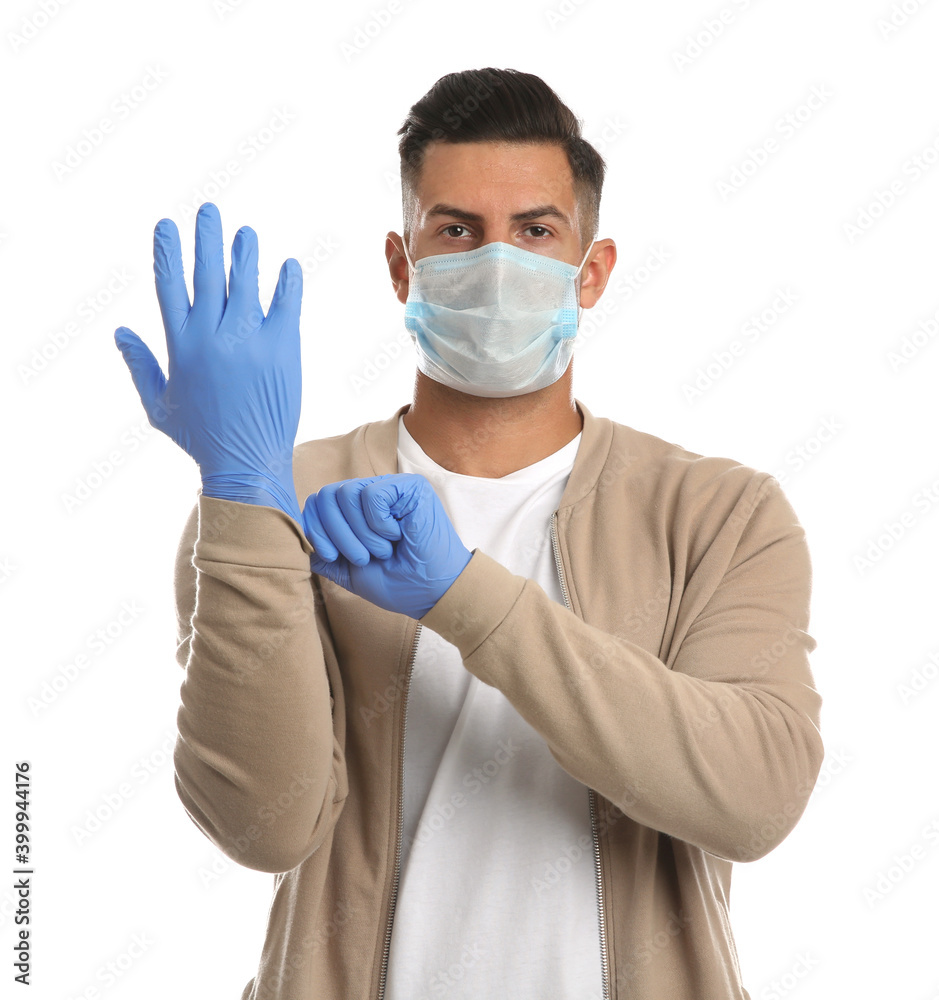 Man in protective face mask putting on medical gloves against white background Man in protective face mask putting on medical gloves against white background
