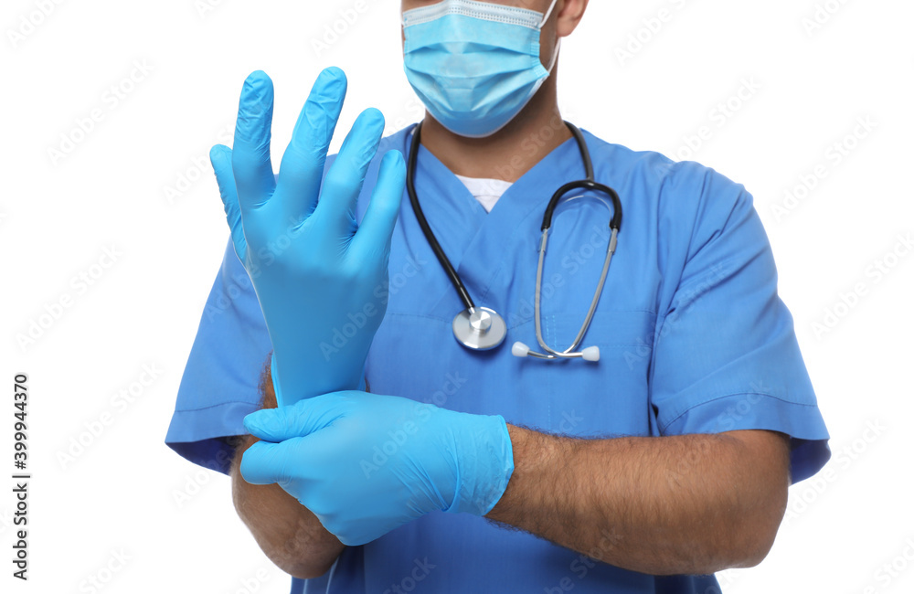 Doctor in protective mask putting on medical gloves against white background, closeup Doctor in protective mask putting on medical gloves against white background, closeup