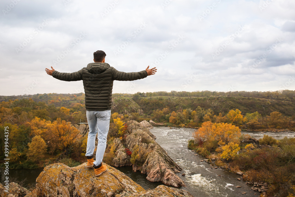 Man enjoying beautiful nature near mountain river, back view Man enjoying beautiful nature near mountain river, back view