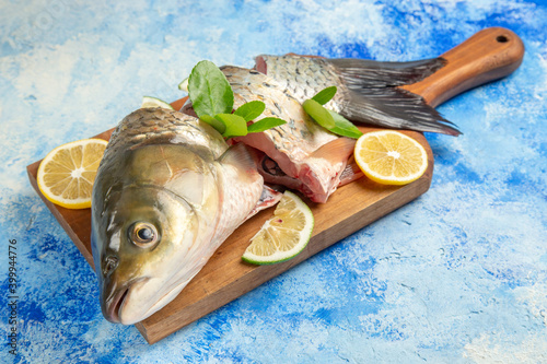 front view sliced fresh fish with lemon slices on blue background ocean dish food seafood photo