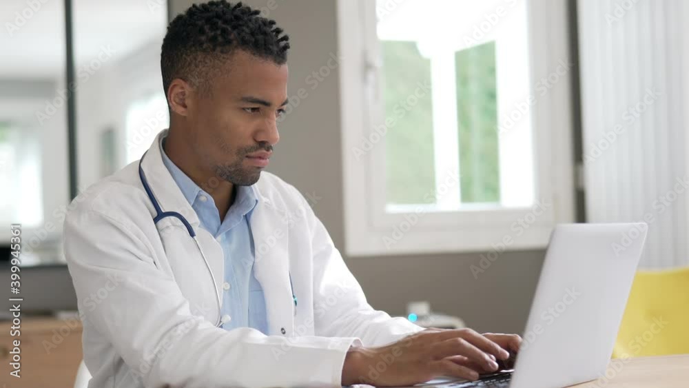 Portrait of general practitioner working in office in laptop