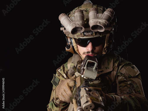 Delta Force soldier, US army special forces. Combat application group, Army compartmented element operator - Tier 1. Portrait on a black backdrop with rifle and night vision. photo