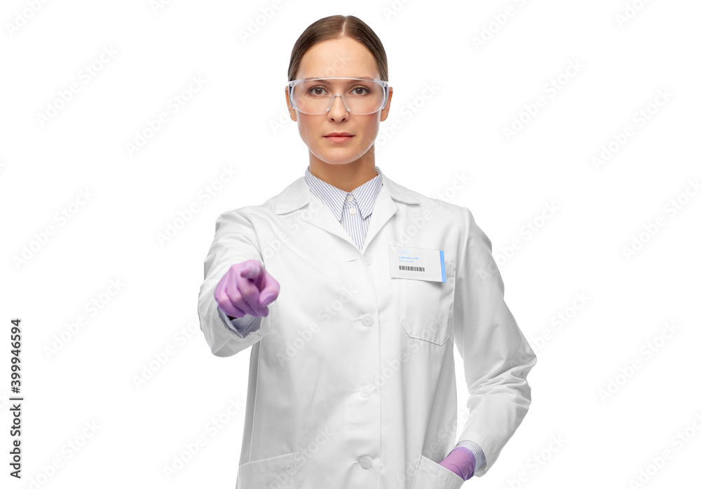 science and profession concept - female scientist in goggles and gloves with nametag on lab coat pointing to camera science and profession concept - female scientist in goggles and gloves with nametag on lab coat pointing to camera