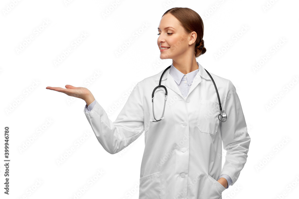 medicine, profession and healthcare concept - happy smiling female doctor in white coat with stethoscope holding something invisible on her hand medicine, profession and healthcare concept - happy smiling female doctor in white coat with stethoscope holding something invisible on her hand