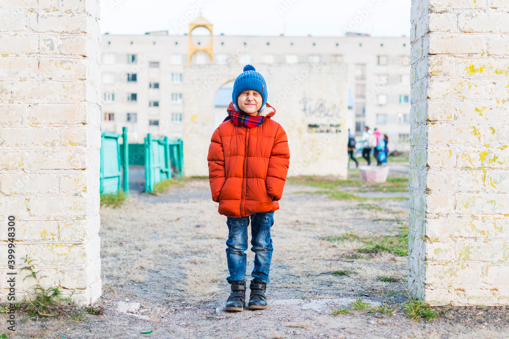 portrait of a boy in full growth in the autumn. The boy grimaces.