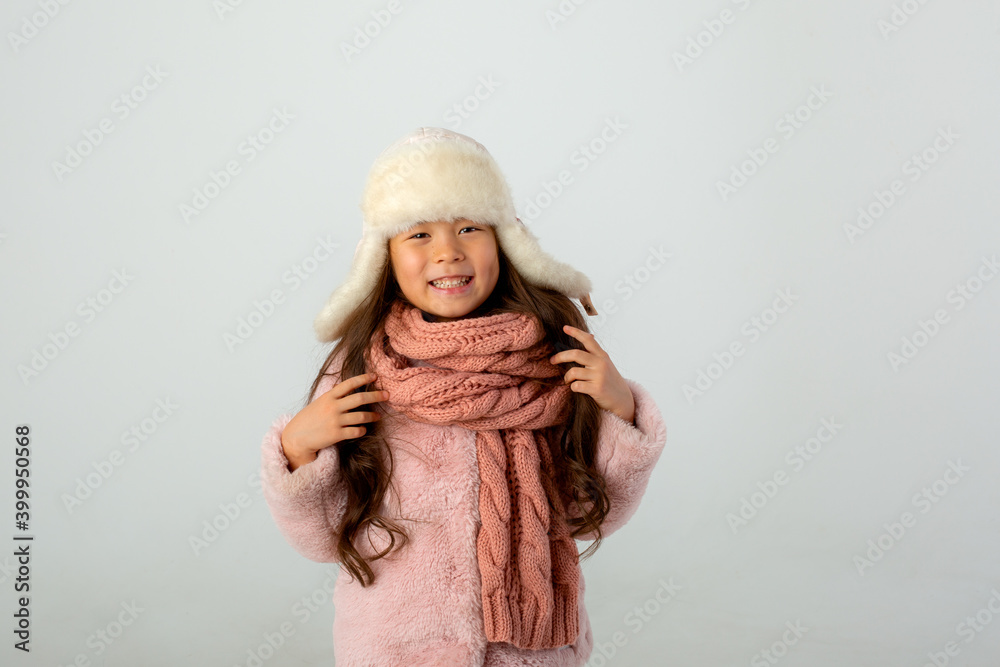 cute little girl dressed in a winter white hat and clothes  on a white background