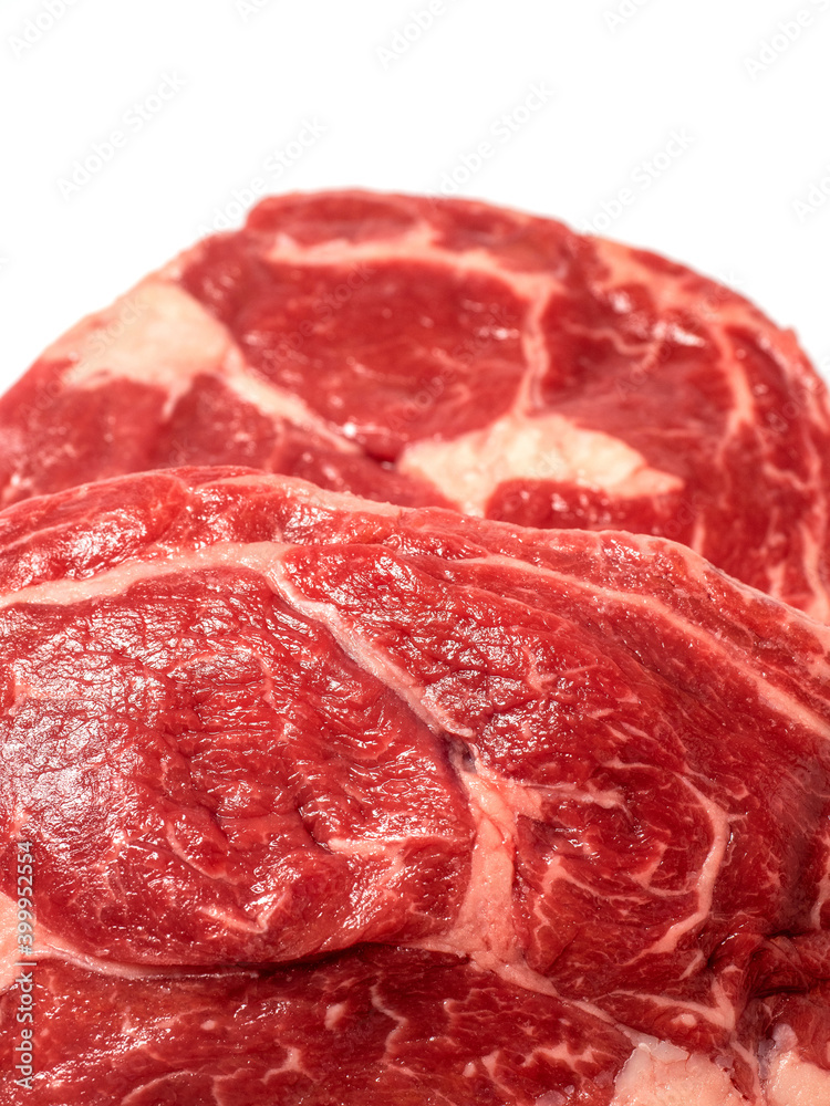 Fresh raw rib eye steak on white isolated surface. Meat industry product. Premium tender meat cut. Close up Fresh raw rib eye steak on white isolated surface. Meat industry product. Premium tender meat cut. Close up