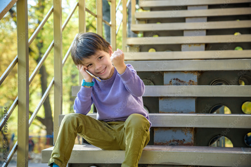 Happy boy talking excited with opened mouth on smartphone. Outdoor. Technology, winning, people, children concept
