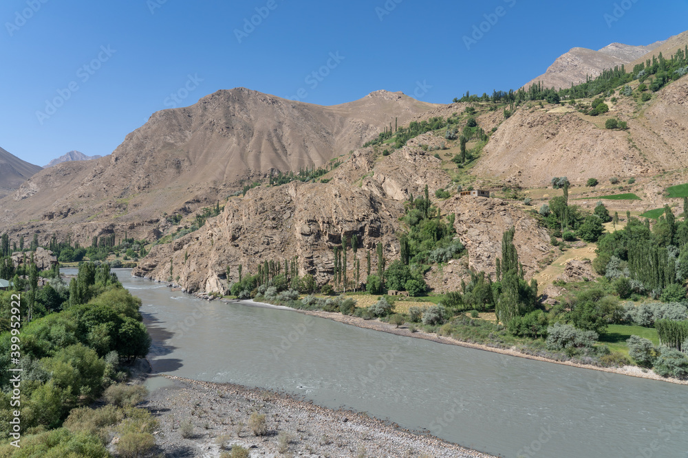 Landscape view of Panj river valley, border between Tajikistan and Afghanistan near Khorog in mountainous Gorno-Badakshan the Pamir region of Tajikistan Landscape view of Panj river valley, border between Tajikistan and Afghanistan near Khorog in mountainous Gorno-Badakshan the Pamir region of Tajikistan