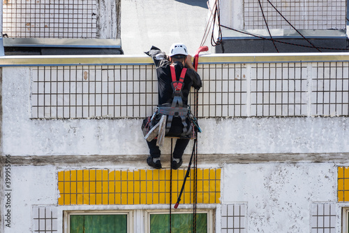 Industrial climber washes windows in high-rise building