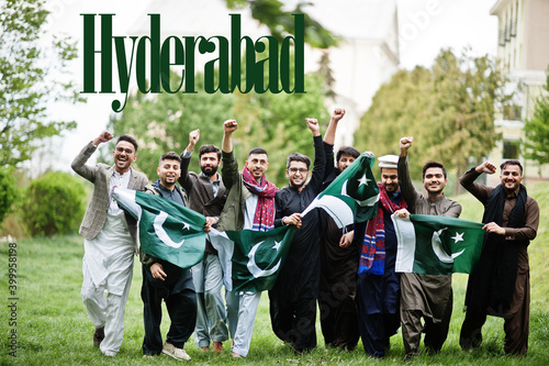 Hyderabad city. Group of pakistani man wearing traditional clothes with national flags. Biggest cities of Pakistan concept.