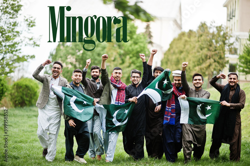 Mingora city. Group of pakistani man wearing traditional clothes with national flags. Biggest cities of Pakistan concept.