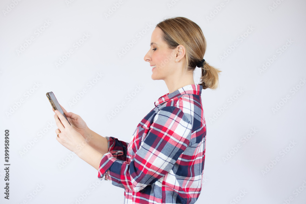 Portrait of a smiling casual woman holding mobile phone over white background Portrait of a smiling casual woman holding mobile phone over white background
