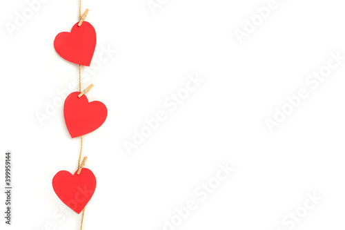 Corazones rojos de papel colgados de una cuerda sobre un fondo blanco liso y aislado. Vista de frente Copy space. Concepto: Día de San Valentín, matrimonio, día de la madre, concepto de amor.