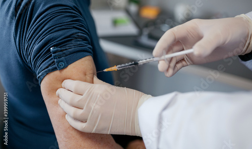 Closeup of arm of unrecognizable adult receiving coronavirus vaccine
