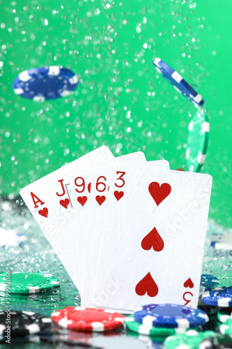 Wallpaper Mural Flush poker combination under the water drops and falling poker chips against green background. Online gambling. Betting. Gambling addiction. Torontodigital.ca