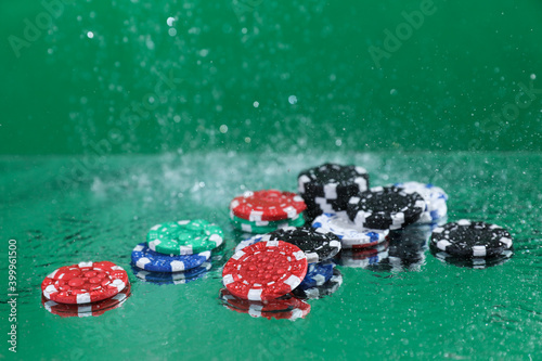 Wallpaper Mural Close up of poker playing chips falling on a green table under the water drops against green background Online gambling. Addiction. Casino. Torontodigital.ca