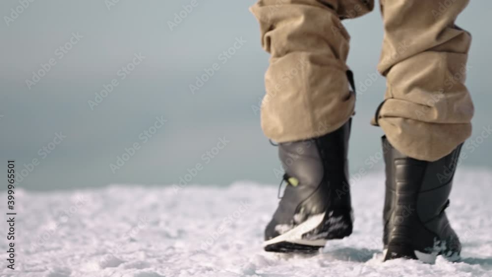 Close up of snowboard boots walking on snow shot in 4k Close up of snowboard boots walking on snow shot in 4k