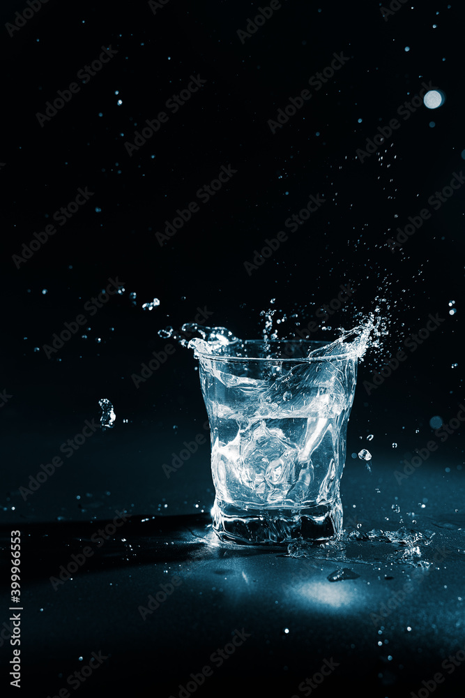 Pure water splashing out of glass on black background