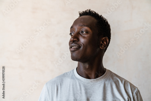 Young handsome african american man smiling and looking aside indoors
