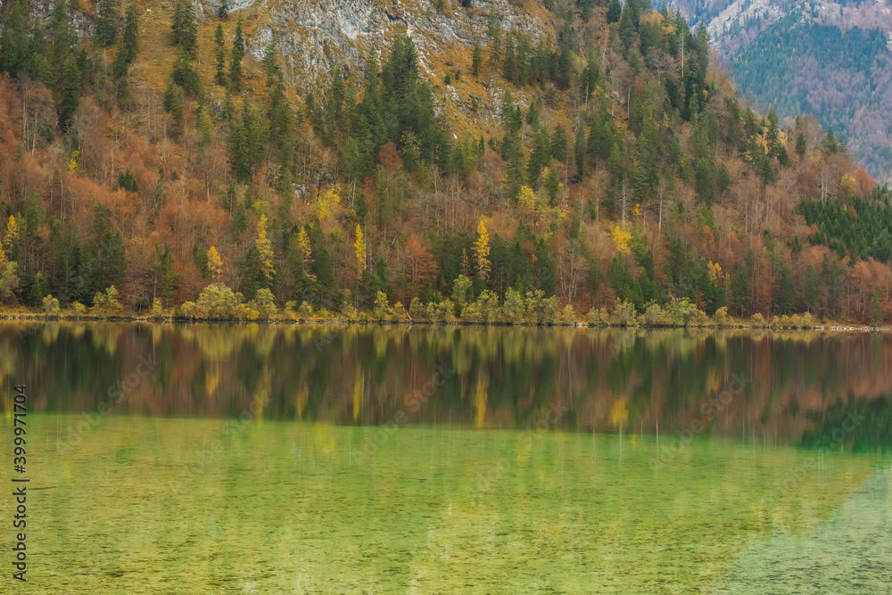 green yellow reflection from the forest and mountain in a lake
