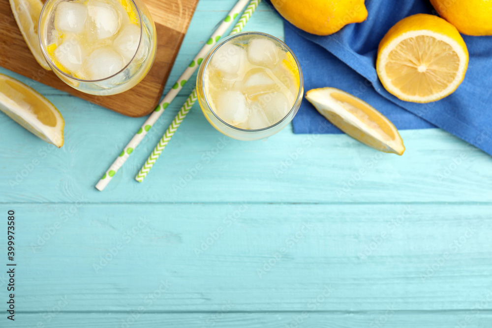 Soda water with lemon slices and ice cubes on light blue wooden table, flat lay. Space for text Soda water with lemon slices and ice cubes on light blue wooden table, flat lay. Space for text