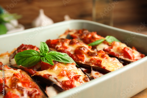 Baked eggplant with tomatoes, cheese and basil in dishware, closeup