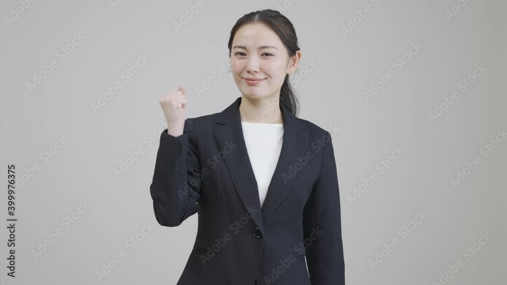 若いビジネスウーマンがガッツポーズをしている 若いビジネスウーマンがガッツポーズをしている