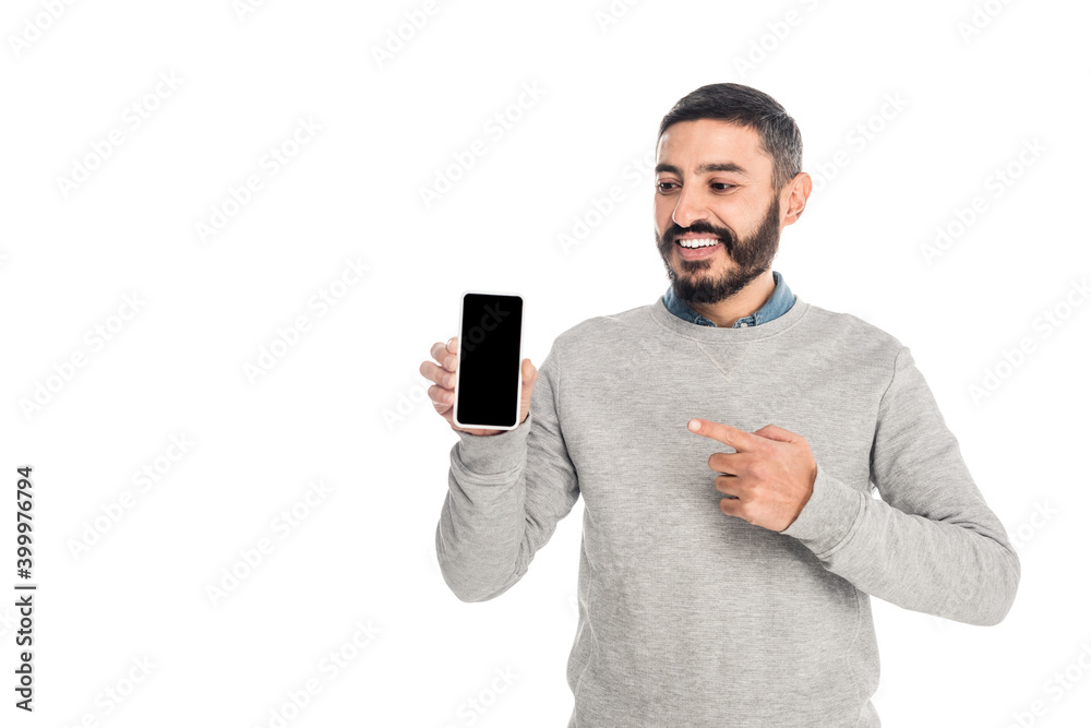 cheerful hispanic man pointing with finger at smartphone with blank screen isolated on white cheerful hispanic man pointing with finger at smartphone with blank screen isolated on white