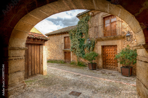 Imagen de un arco y unas casas de Pedraza que es un pueblo turístico y con mucho encanto de la provincia de Salamanca .