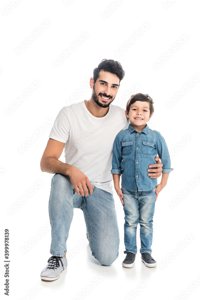 happy hispanic man hugging happy son while looking at camera on white, two generations of men happy hispanic man hugging happy son while looking at camera on white, two generations of men