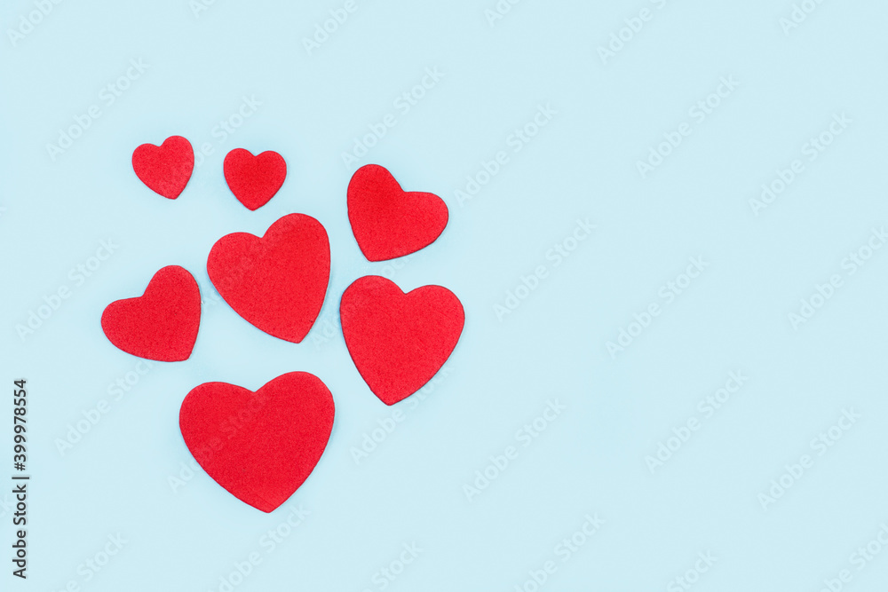 Corazones rojos de diferentes tamaños sobre un fondo celeste pastel liso y aislado. Copy space. Concepto: Día de San Valentín, matrimonio, día de la madre, concepto de amor. Corazones rojos de diferentes tamaños sobre un fondo celeste pastel liso y aislado. Copy space. Concepto: Día de San Valentín, matrimonio, día de la madre, concepto de amor.
