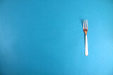 fork isolated on blue background flat lay