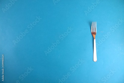 fork isolated on blue background flat lay