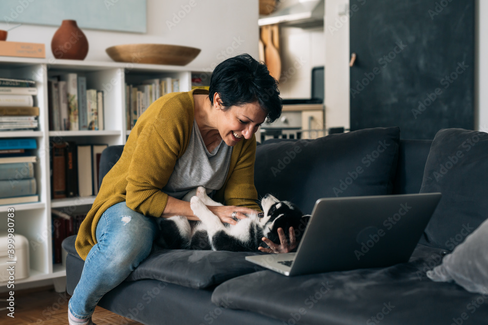 woman playing with her siberian husky puppy at home