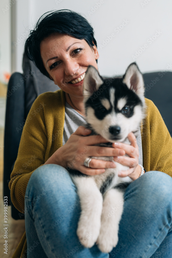 woman with her siberian husky puppy at home woman with her siberian husky puppy at home