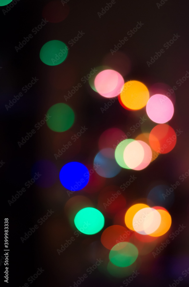 Abstract colored bokeh background of blurred lights garland on black background, for Christmas, New year and holidays