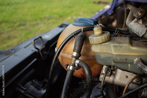 Engine cooling system expansion tank against the background of grass 