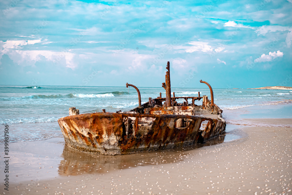 Old rusty ship stay abandoned on the beach in Israel. beautiful view with destroyed boat. place for photo shooting pirates and sailors.
