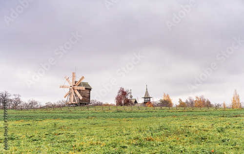 Historic site of wooden church and windmill of Kizhi Island, Republic of Karelia, Russia. Moody autumn landscape.