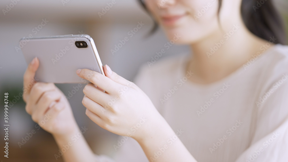 スマートフォンで動画を観る若い女性 スマートフォンで動画を観る若い女性